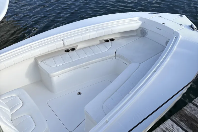 Slide: The Image of 2014 Regulator 25 boat interior with white cushioned seating and cup holders. - 24
