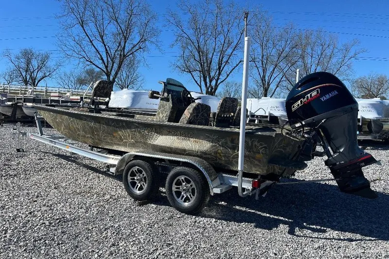Slide: The Image of 2026 War Eagle 2170 Blackhawk boat with Yamaha motor on trailer, parked outdoors. - 1