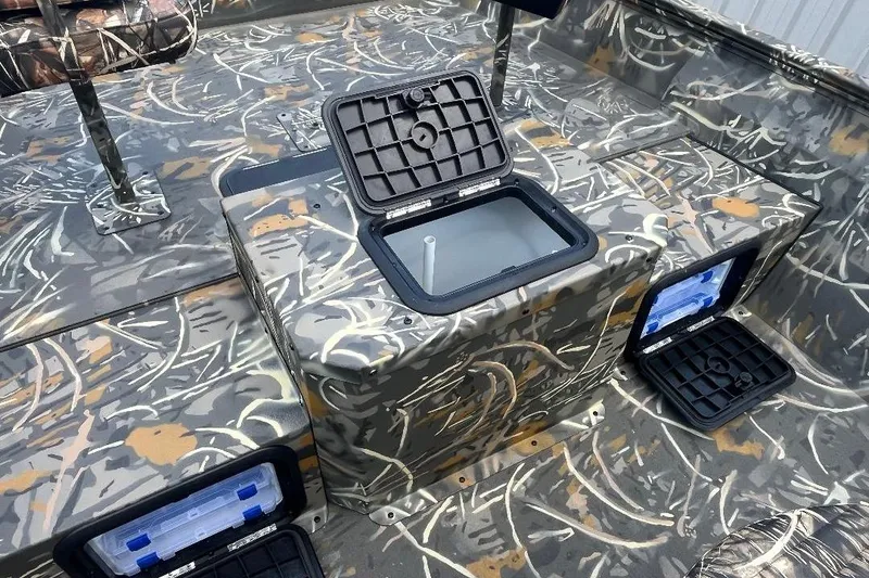 Slide: The Image of 2026 War Eagle 2170 Blackhawk boat interior with camo design and storage compartments open. - 14