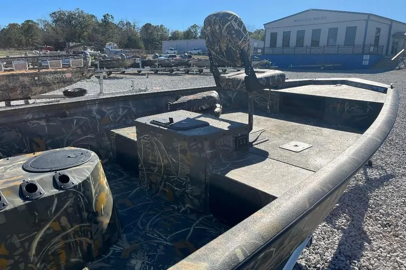 Slide: The Image of 2026 War Eagle 2170 Blackhawk boat with camouflage design, parked outdoors. - 19