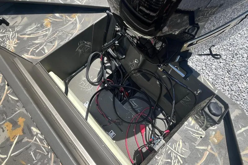 Slide: The Image of Open compartment of 2026 War Eagle 2170 Blackhawk boat showing wiring and camouflage interior. - 4