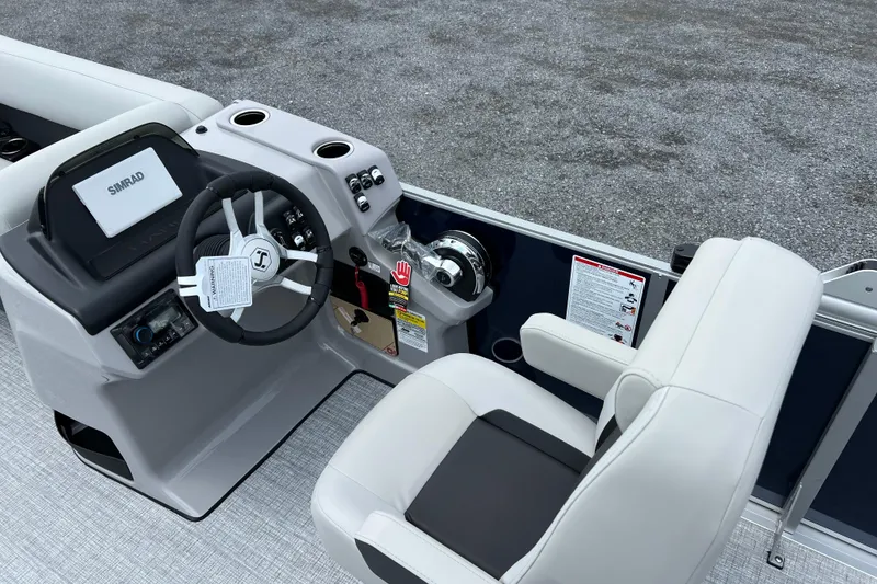 Slide: The Image of 2025 Harris Cruiser 230 boat helm with steering wheel, Simrad display, and comfortable seating. - 8