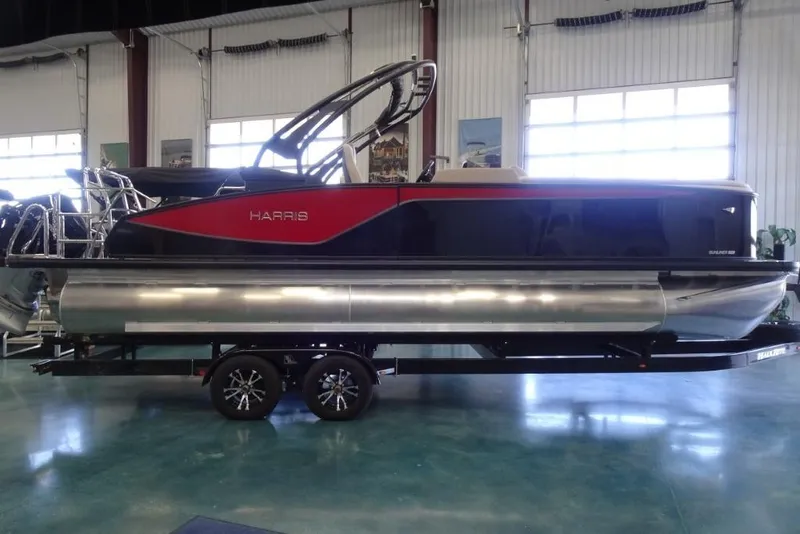 Slide: The Image of 2026 Harris Sunliner 250 Sport pontoon boat on trailer in showroom. - 2