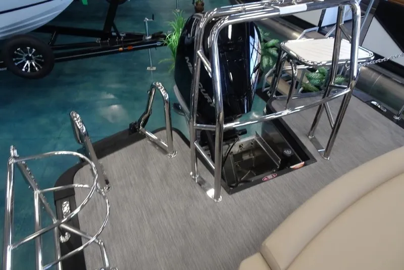 Slide: The Image of 2026 Harris Sunliner 250 Sport boat interior with chrome railings and motor, displayed indoors. - 26