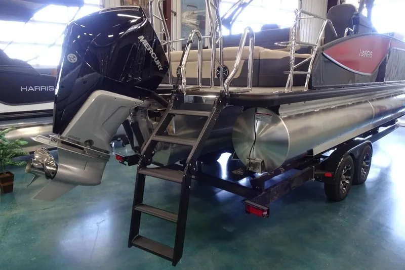 Slide: The Image of 2026 Harris Sunliner 250 Sport pontoon boat with Mercury outboard engine on display. - 3