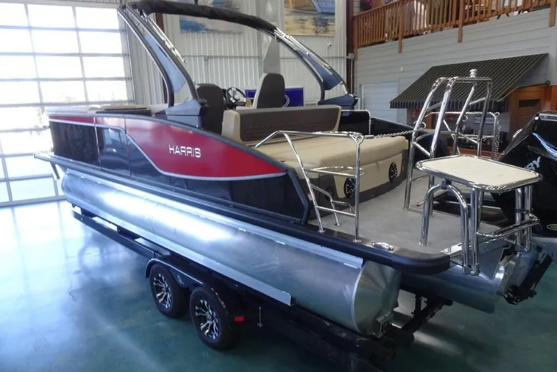 Slide: The Image of 2026 Harris Sunliner 250 Sport pontoon boat in showroom, featuring sleek design and modern amenities. - 4