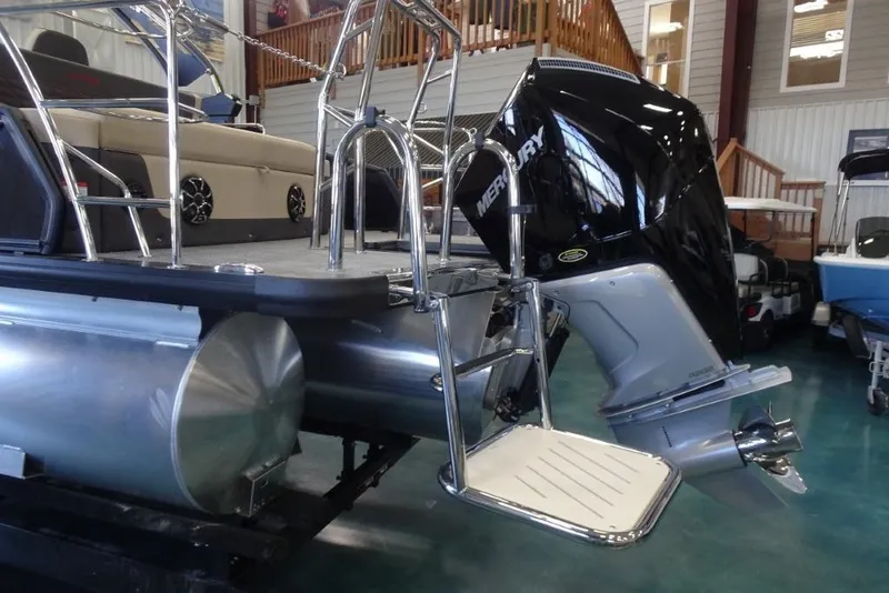 Slide: The Image of 2026 Harris Sunliner 250 Sport pontoon boat with Mercury outboard motor in showroom. - 6