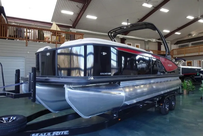 Slide: The Image of 2026 Harris Sunliner 250 Sport pontoon boat displayed indoors on a trailer. - 8
