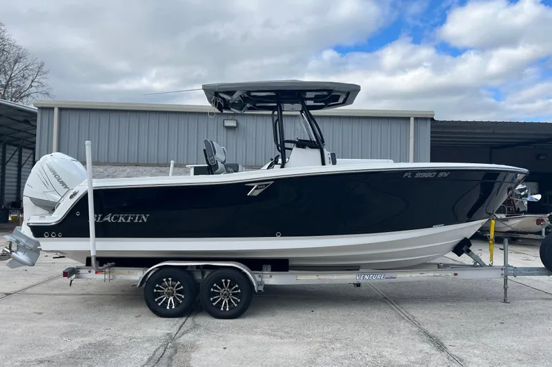 The Image of 2021 Blackfin 252 CC boat on trailer, parked outside a warehouse. - 0