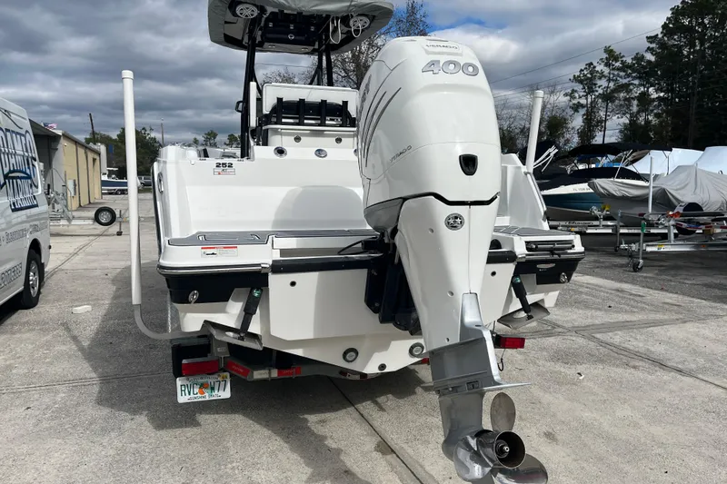 Slide: The Image of 2021 Blackfin 252 CC boat with powerful outboard motor, parked on concrete lot. - 11
