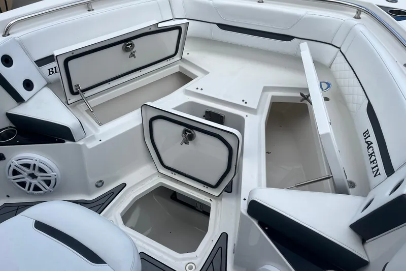 Slide: The Image of 2021 Blackfin 252 CC boat interior with open storage compartments and seating. - 19