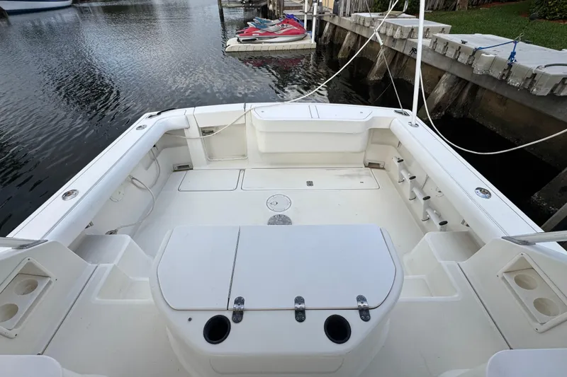 Slide: The Image of 1995 Pursuit 3000 Express boat interior with seating and storage, docked by the water. - 13