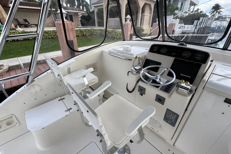 Slide: The Image of 1995 Pursuit 3000 Express boat cockpit with steering wheel and control panel. - 14