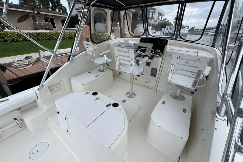 Slide: The Image of 1995 Pursuit 3000 Express boat interior with helm, seating, and waterfront view. - 17