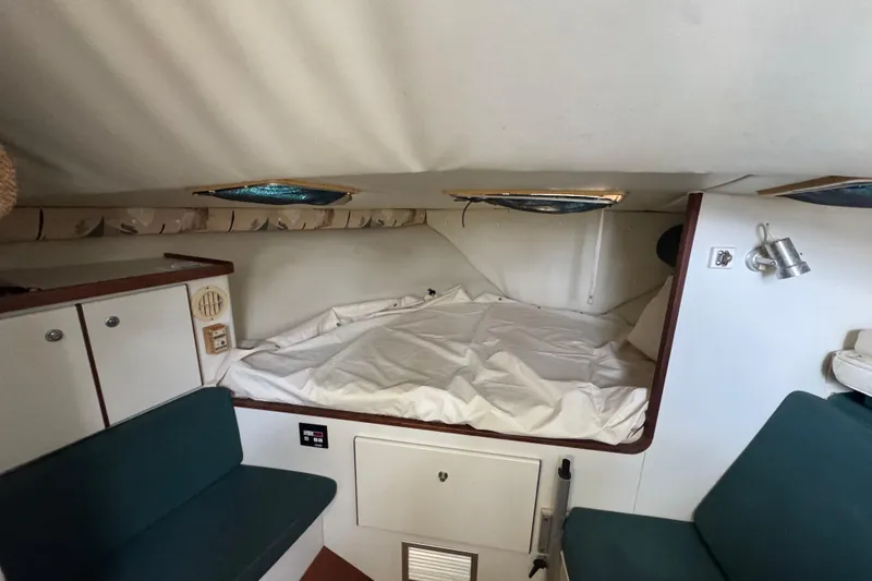 Slide: The Image of 1995 Pursuit 3000 Express cabin interior with bed, seating, and storage. - 22