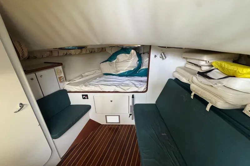 Slide: The Image of 1995 Pursuit 3000 Express cabin interior with bed, seating, and storage. - 23