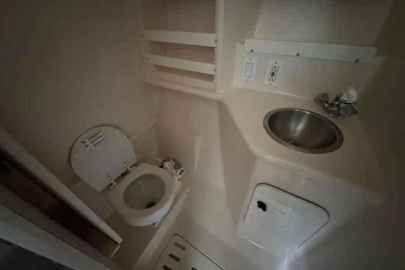 Slide: The Image of 1995 Pursuit 3000 Express boat bathroom with toilet and sink. - 24