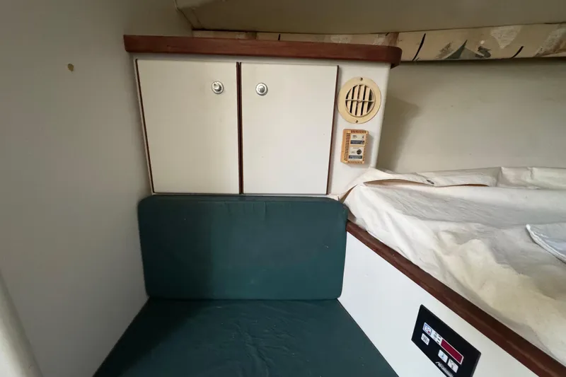 Slide: The Image of 1995 Pursuit 3000 Express cabin interior with storage, seating, and control panel. - 26