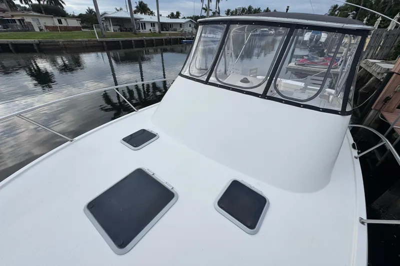 Slide: The Image of 1995 Pursuit 3000 Express boat docked by a calm canal. - 28