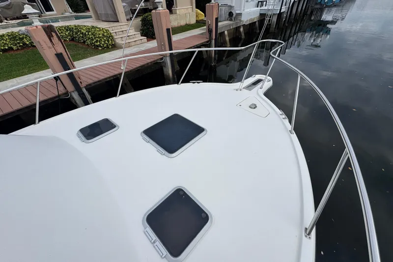Slide: The Image of 1995 Pursuit 3000 Express boat docked, showing bow and deck hatches. - 30