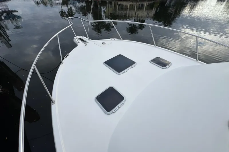 Slide: The Image of 1995 Pursuit 3000 Express boat deck with hatches, docked on calm water. - 31