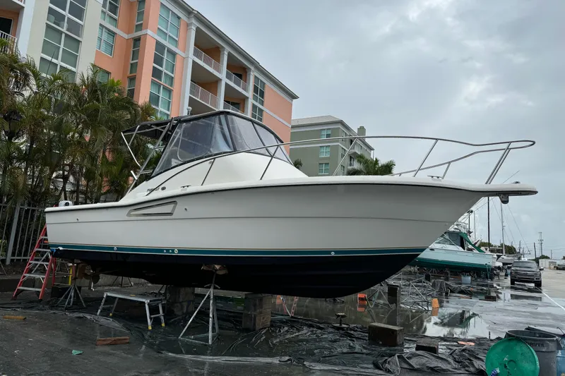 Slide: The Image of 1995 Pursuit 3000 Express boat on dry dock near residential buildings. - 36