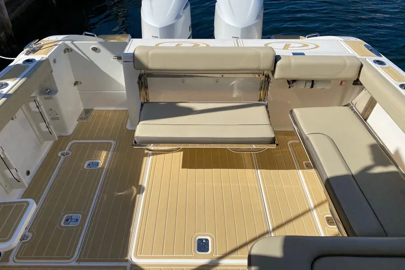Slide: The Image of 2020 Pursit DC 325 boat interior with beige seating and teak-style flooring. - 11