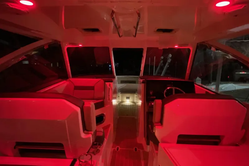 Slide: The Image of Interior of 2020 Pursit DC 325 boat with red ambient lighting. - 19