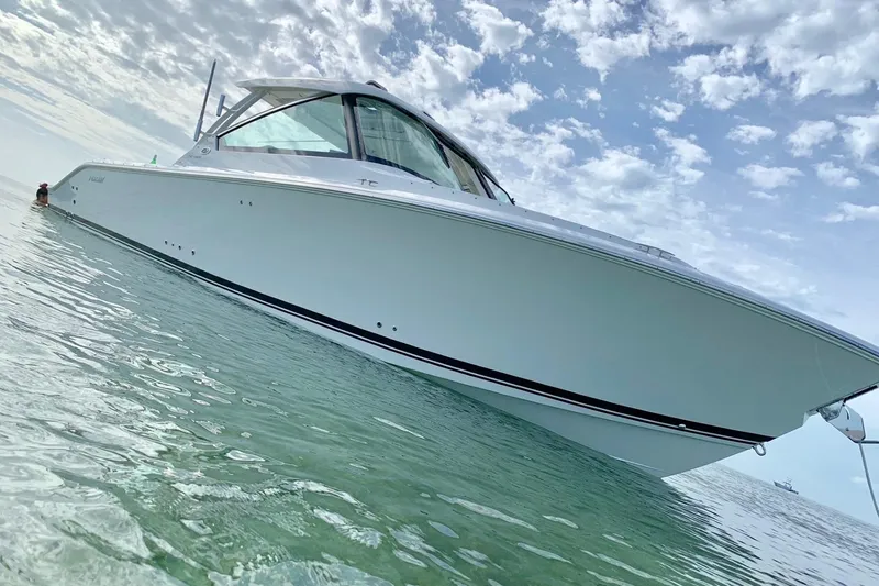 Slide: The Image of 2020 Pursit DC 325 boat on clear water under a partly cloudy sky. - 3