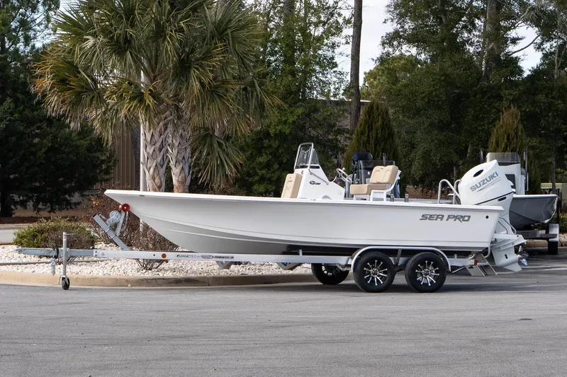 The Image of 2026 Sea Pro 210 Bay boat on trailer, parked near palm trees. - 1