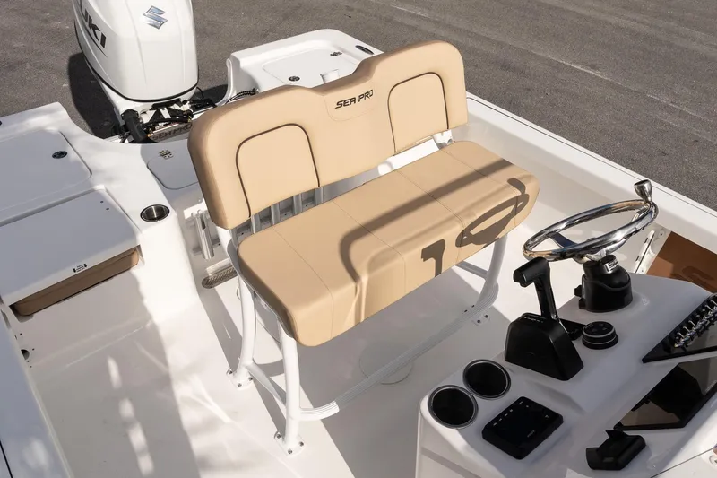 Slide: The Image of 2026 Sea Pro 210 Bay boat interior with beige seating and steering console. - 12