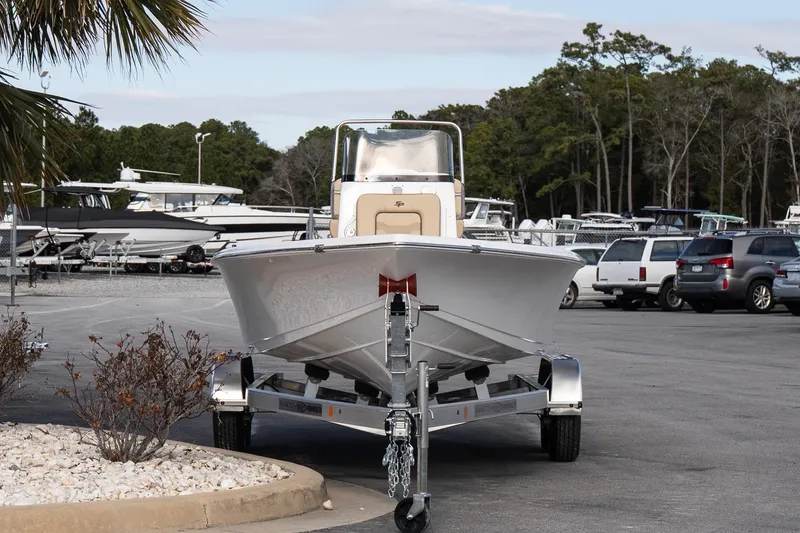Slide: The Image of 2026 Sea Pro 210 Bay boat on trailer in parking lot, surrounded by trees and vehicles. - 3