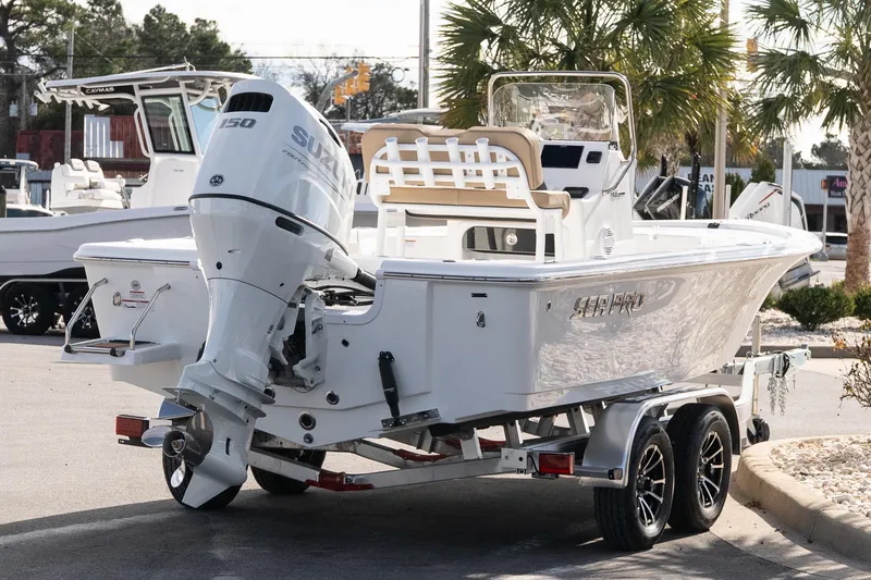 Slide: The Image of 2026 Sea Pro 210 Bay boat on trailer with Suzuki outboard motor, parked outdoors. - 6