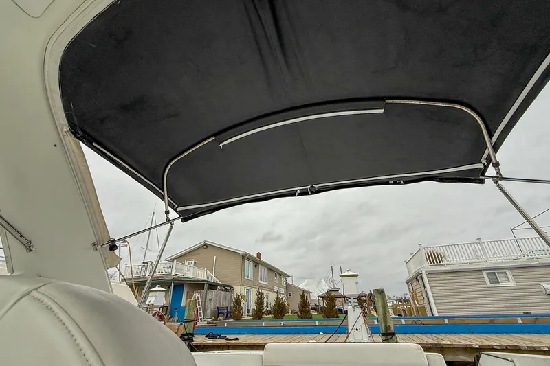 Slide: The Image of 2004 Formula 330 Sun Sport boat with canopy, docked near waterfront homes. - 19