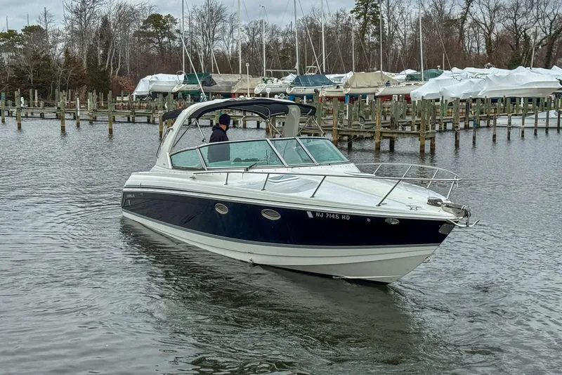 Slide: The Image of 2004 Formula 330 Sun Sport boat navigating a marina with docked vessels. - 3