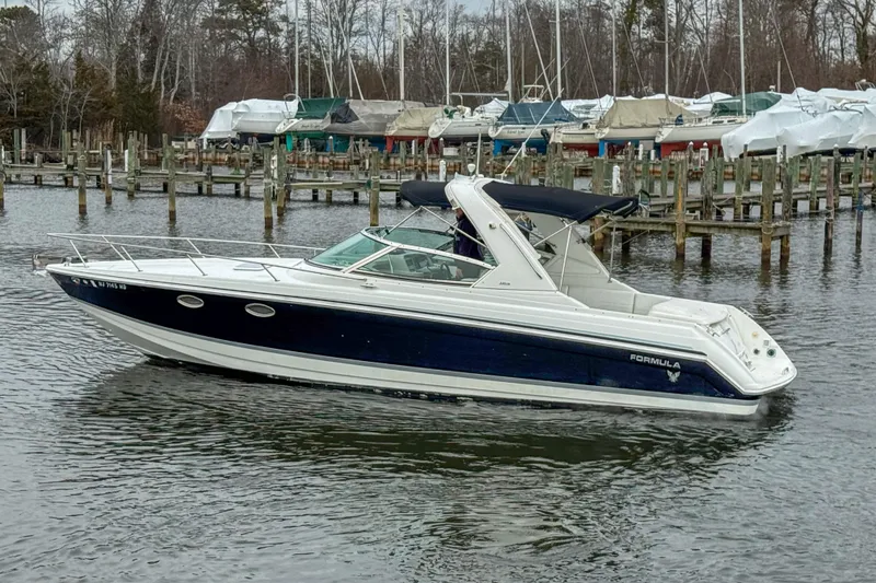 Slide: The Image of 2004 Formula 330 Sun Sport boat docked in a marina with covered boats. - 5