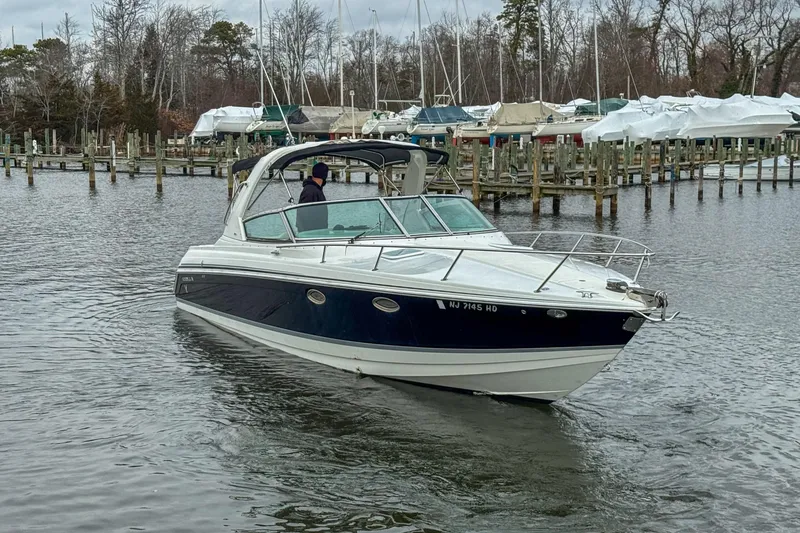 Slide: The Image of 2004 Formula 330 Sun Sport boat cruising in a marina with docked vessels. - 6