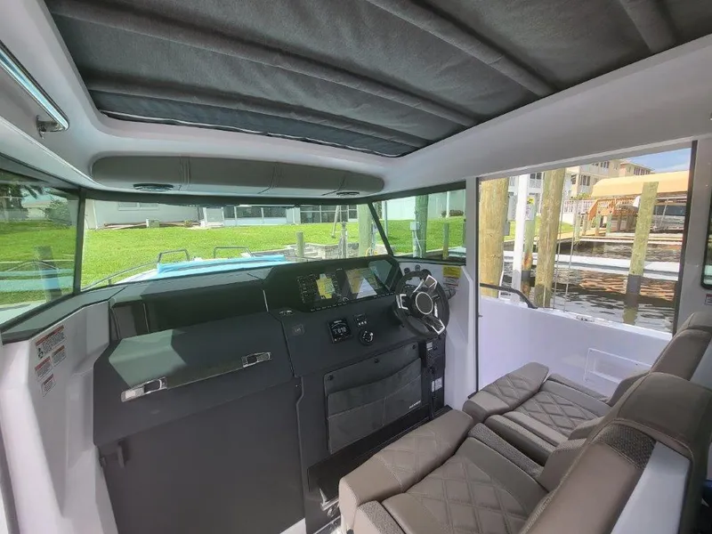 Slide: The Image of Interior of 2024 Axopar 37 XC CROSS CABIN, featuring modern helm and seating. - 14