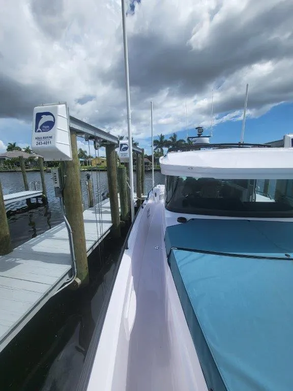 Slide: The Image of 2024 Axopar 37 XC CROSS CABIN docked under cloudy sky. - 21