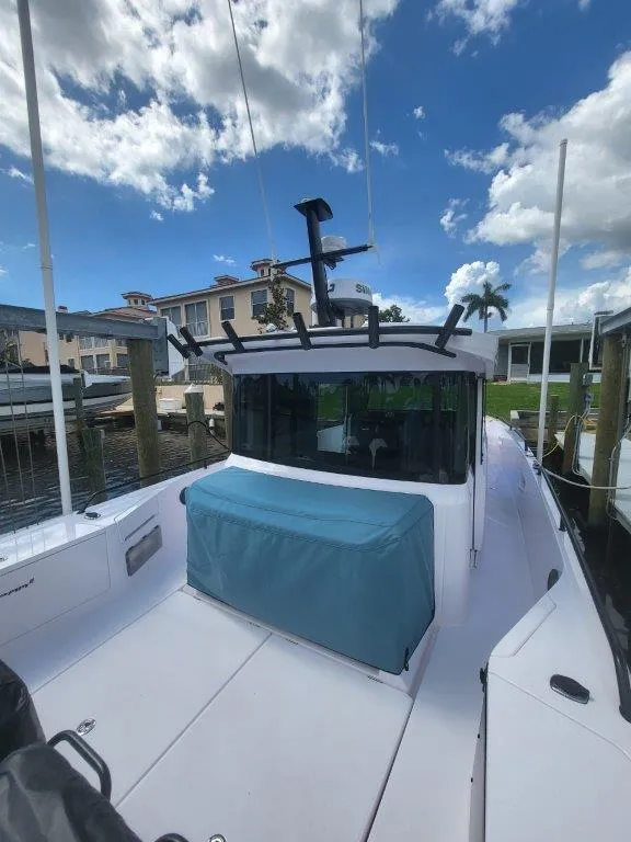 Slide: The Image of 2024 Axopar 37 XC CROSS CABIN boat docked under a blue sky. - 23