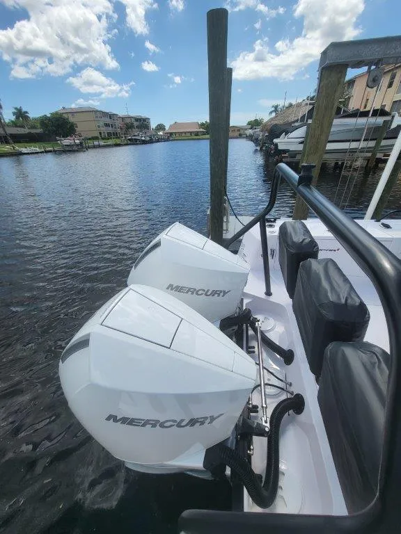 Slide: The Image of 2024 Axopar 37 XC CROSS CABIN with dual Mercury outboard engines docked by the water. - 24