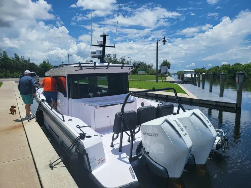 Slide: The Image of 2024 Axopar 37 XC CROSS CABIN docked with twin Mercury engines under a blue sky. - 3