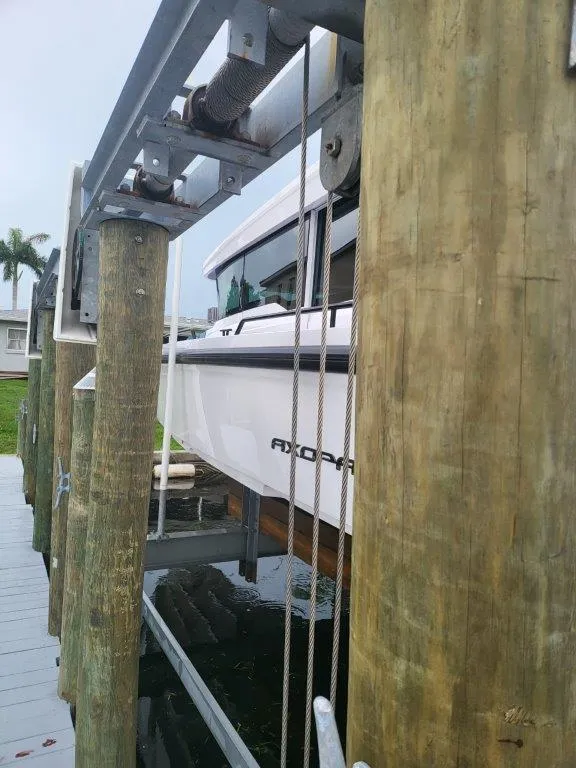 Slide: The Image of 2024 Axopar 37 XC CROSS CABIN boat on a lift by wooden dock. - 7