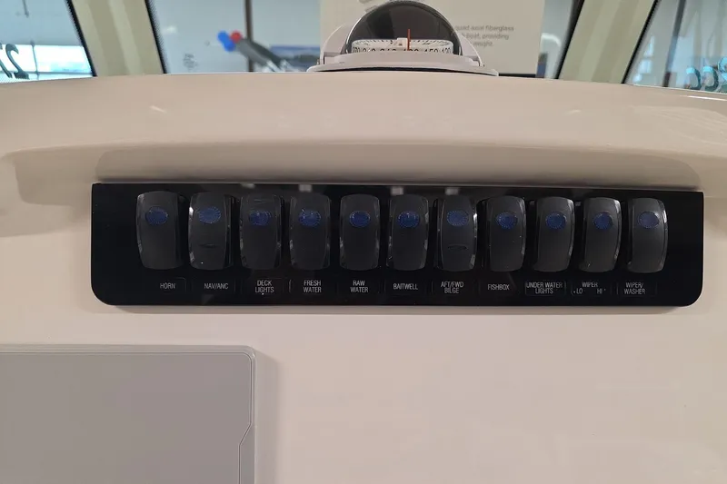 Slide: The Image of Control panel of 2026 Sailfish 272 CC boat with labeled switches for various functions. - 12
