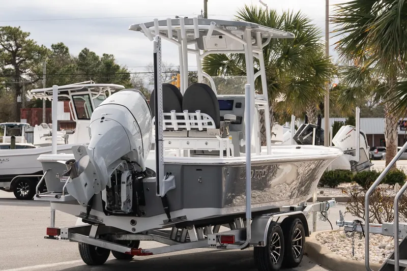 Slide: The Image of 2025 Sea Pro 230 Bay boat on trailer, parked outdoors near palm trees. - 6