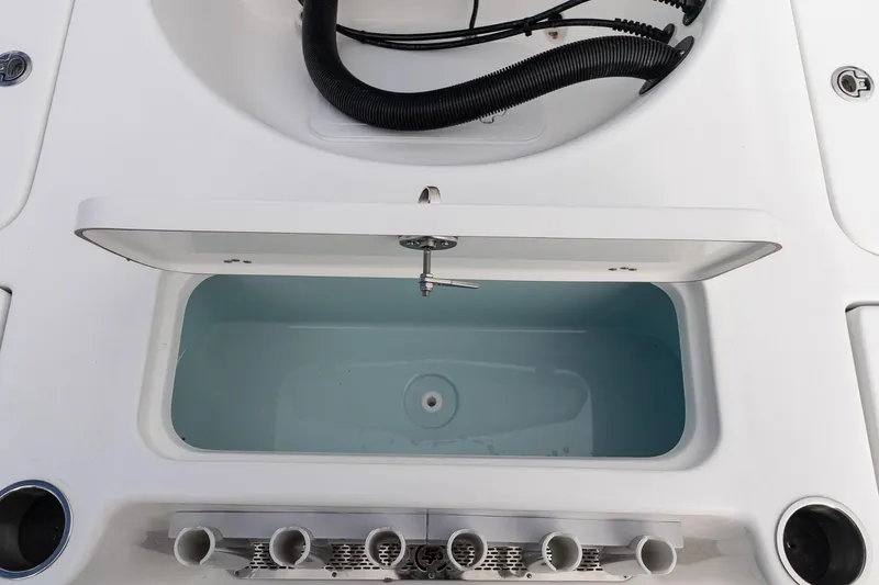 Slide: The Image of 2025 Sea Pro 230 Bay boat livewell with open lid and rod holders. - 11