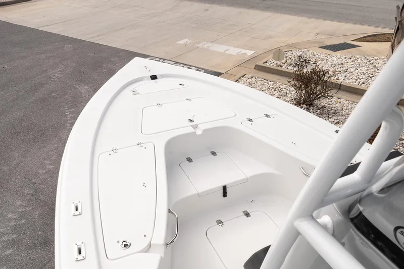 Slide: The Image of 2025 Sea Pro 230 Bay boat deck with storage compartments, parked on pavement. - 13