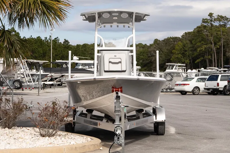 Slide: The Image of 2025 Sea Pro 230 Bay boat on trailer in parking lot, surrounded by trees and vehicles. - 3