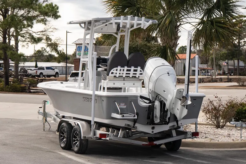 Slide: The Image of 2025 Sea Pro 230 Bay boat on trailer, parked near palm trees. - 4