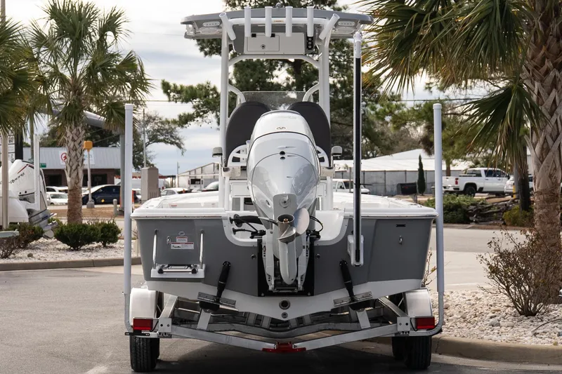 Slide: The Image of 2025 Sea Pro 230 Bay boat on trailer, parked outdoors with palm trees. - 5